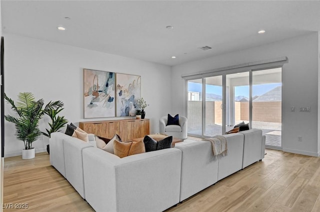 living room with light wood-style floors, recessed lighting, visible vents, and baseboards