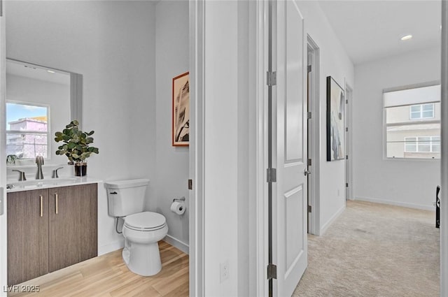 bathroom with vanity, toilet, and baseboards