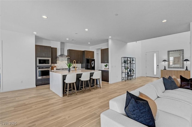 living room featuring light wood-style floors, recessed lighting, and baseboards