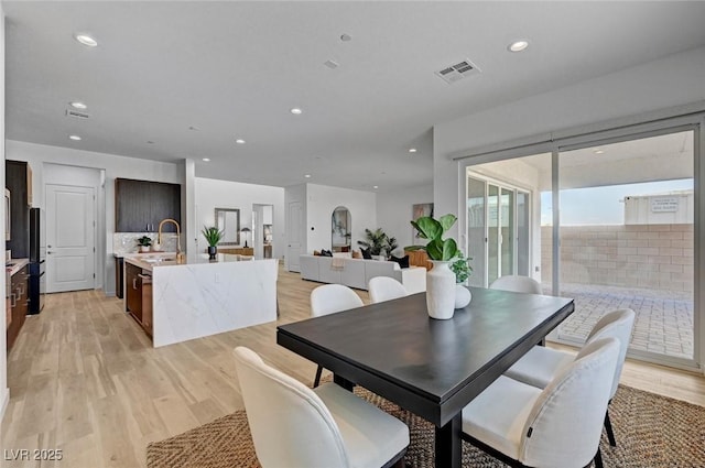 dining area with light wood-style floors, visible vents, and recessed lighting