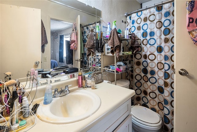 bathroom featuring vanity, curtained shower, and toilet