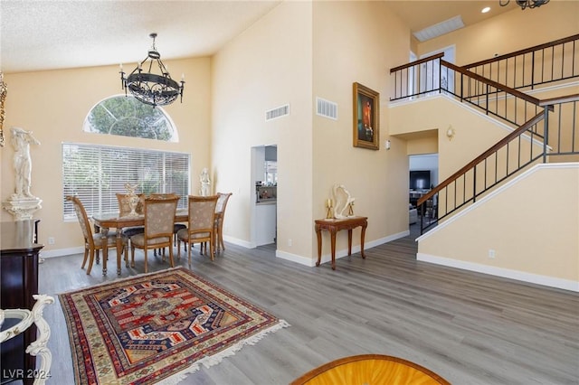 dining area with a chandelier, a textured ceiling, high vaulted ceiling, and dark wood-type flooring