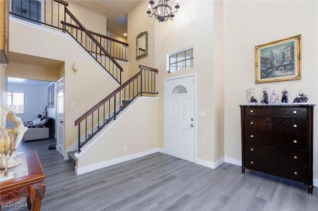 entrance foyer featuring hardwood / wood-style floors, a high ceiling, and a notable chandelier