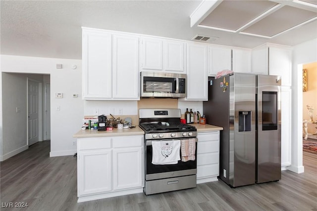 kitchen with white cabinets, appliances with stainless steel finishes, and light hardwood / wood-style flooring