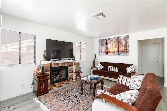 living room with wood-type flooring and a brick fireplace