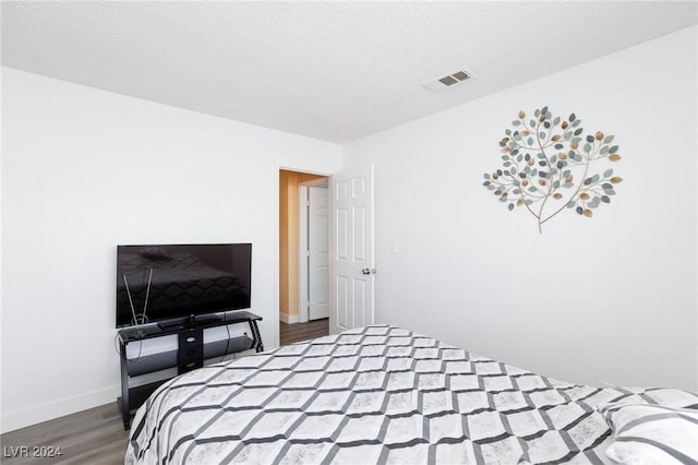 bedroom featuring a textured ceiling and hardwood / wood-style flooring