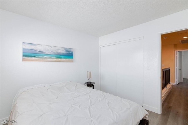 bedroom featuring wood-type flooring and a textured ceiling