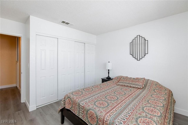 bedroom featuring a textured ceiling, light hardwood / wood-style floors, and a closet