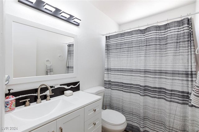 bathroom featuring curtained shower, vanity, and toilet