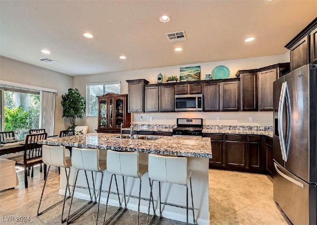 kitchen with a center island with sink, plenty of natural light, sink, and appliances with stainless steel finishes