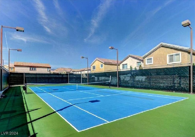 view of tennis court featuring basketball hoop