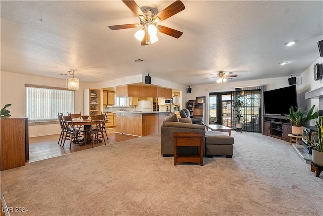 living room with ceiling fan, a healthy amount of sunlight, a textured ceiling, and wood-type flooring