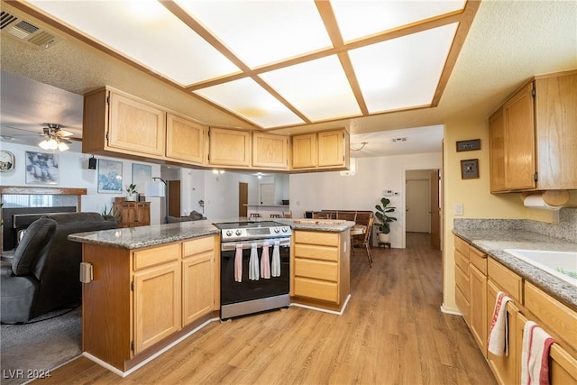 kitchen featuring electric range, ceiling fan, light brown cabinets, light hardwood / wood-style flooring, and kitchen peninsula