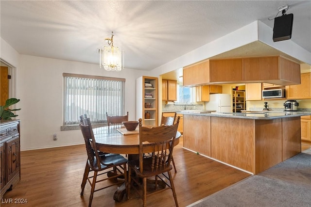 dining room featuring an inviting chandelier, a wealth of natural light, and dark wood-type flooring