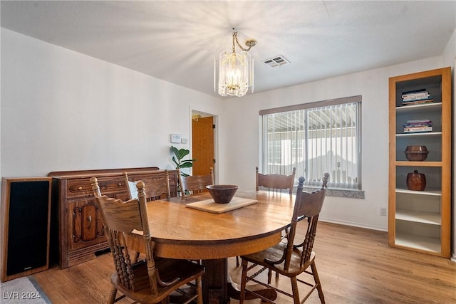 dining room featuring light wood-type flooring and a chandelier