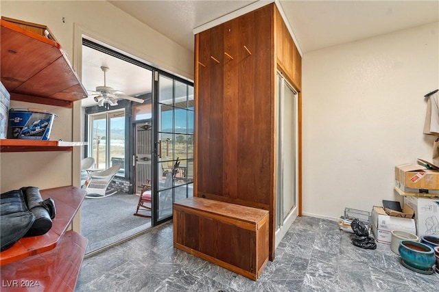 interior space with ceiling fan and dark carpet