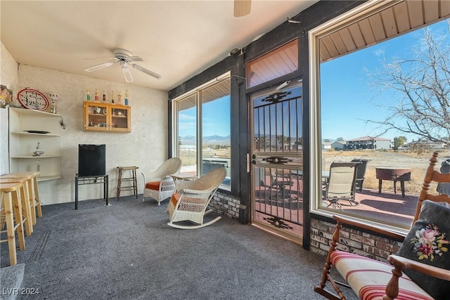 interior space featuring ceiling fan and dark carpet