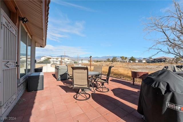 view of patio with a mountain view and a grill