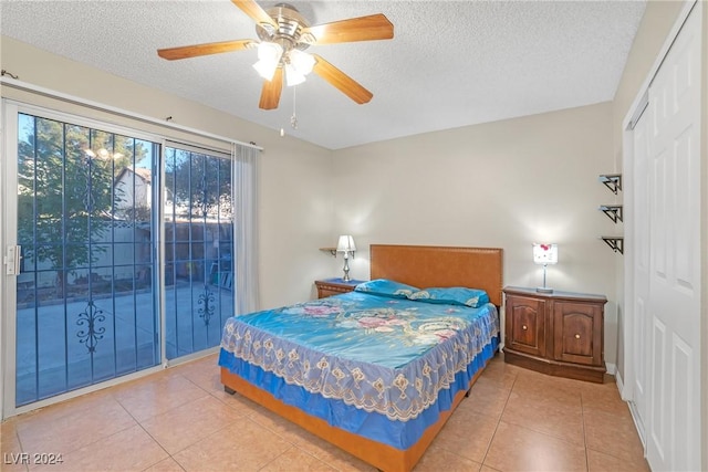 bedroom featuring ceiling fan, tile patterned flooring, and a textured ceiling