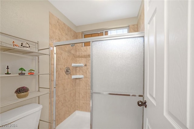 bathroom featuring toilet and an enclosed shower