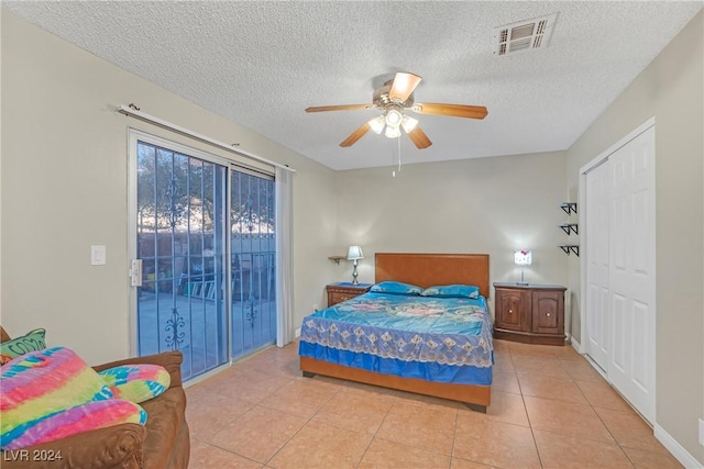 bedroom featuring ceiling fan, light tile patterned flooring, a textured ceiling, and access to outside