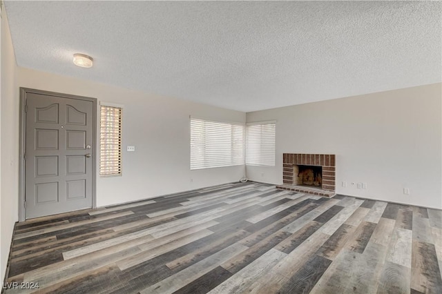 unfurnished living room with a fireplace, wood-type flooring, and a textured ceiling