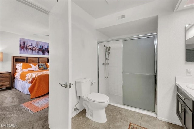 bathroom featuring tile patterned flooring, a shower with door, vanity, and toilet