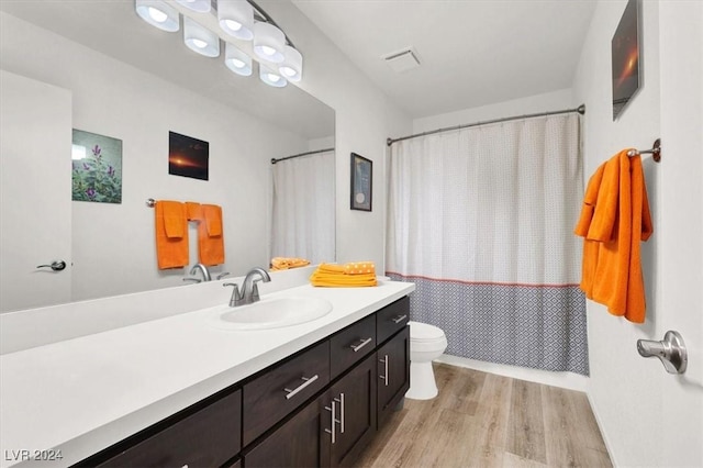 bathroom featuring hardwood / wood-style floors, vanity, toilet, and a shower with shower curtain