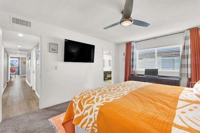 bedroom with hardwood / wood-style floors, ceiling fan, and multiple windows