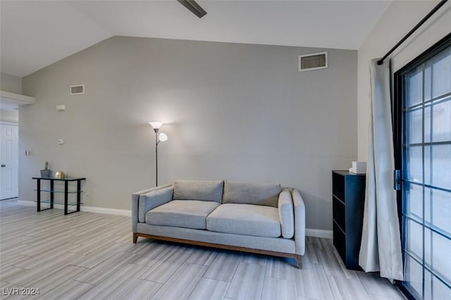 living room featuring light wood-type flooring and vaulted ceiling