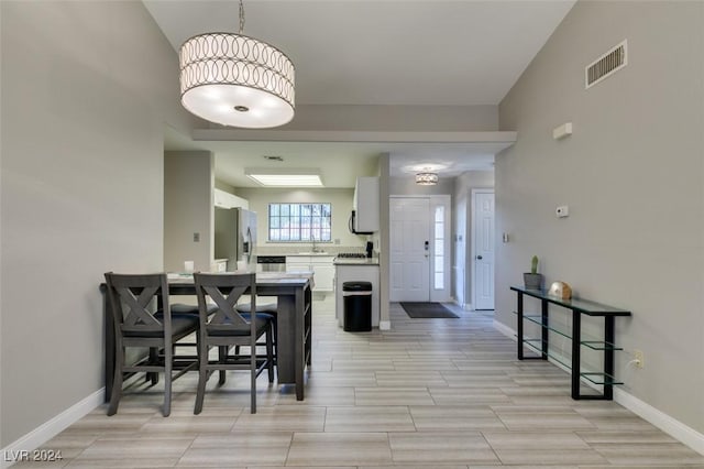 dining area featuring vaulted ceiling and sink