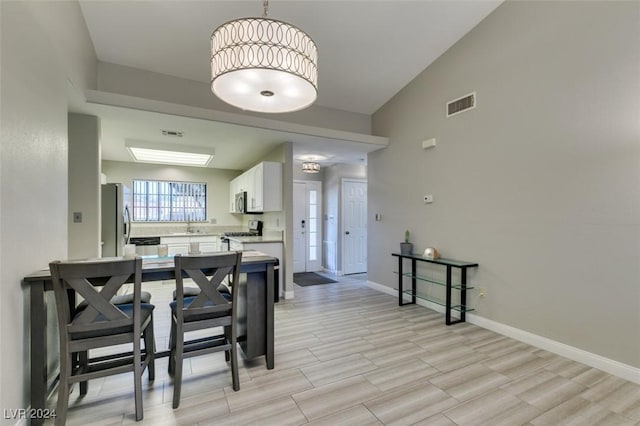 dining space with light hardwood / wood-style flooring and lofted ceiling