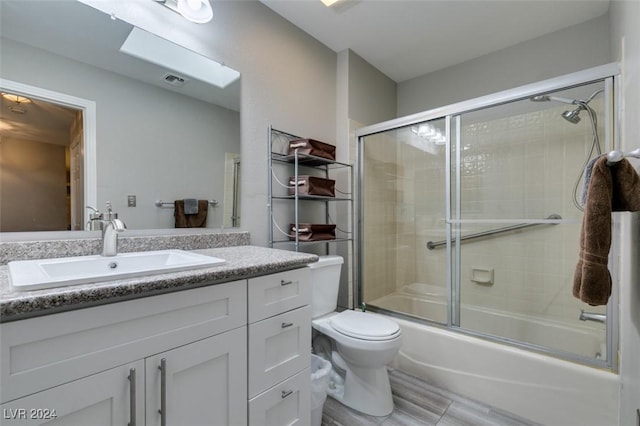 full bathroom with vanity, toilet, and bath / shower combo with glass door