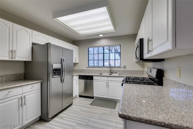 kitchen with white cabinets, stainless steel appliances, light hardwood / wood-style flooring, and sink