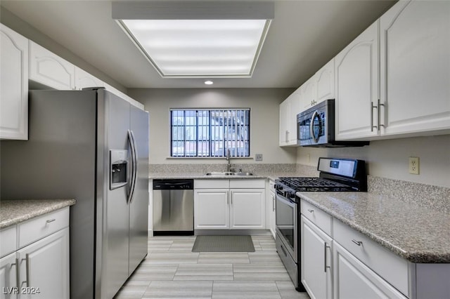 kitchen with sink, white cabinetry, and stainless steel appliances