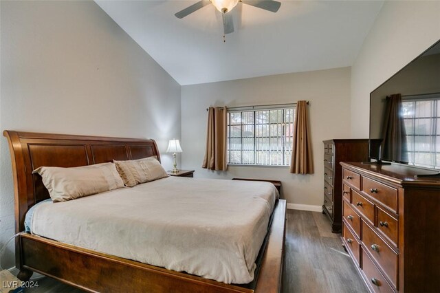 bedroom featuring ceiling fan, dark hardwood / wood-style flooring, and lofted ceiling