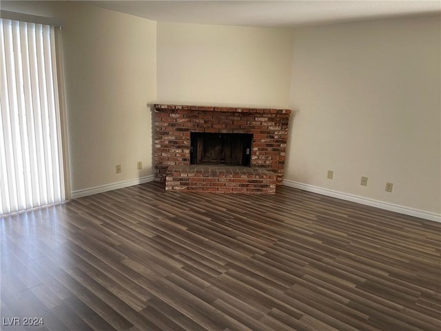 unfurnished living room with a fireplace and dark wood-type flooring