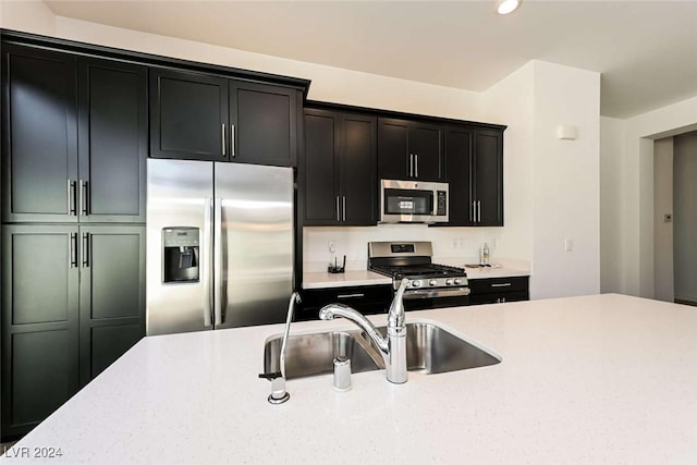 kitchen featuring light stone counters, sink, and stainless steel appliances