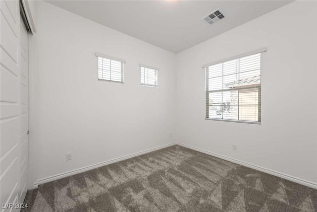 spare room with dark carpet