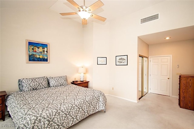 carpeted bedroom featuring ceiling fan and a closet