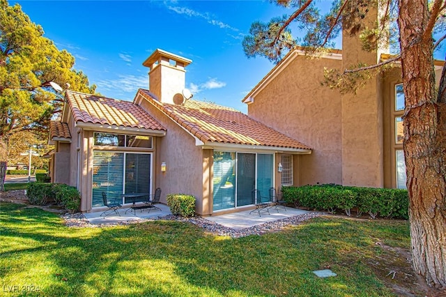 rear view of house with a yard and a patio