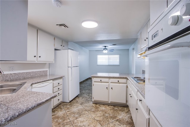 kitchen featuring kitchen peninsula, white appliances, ceiling fan, sink, and white cabinetry