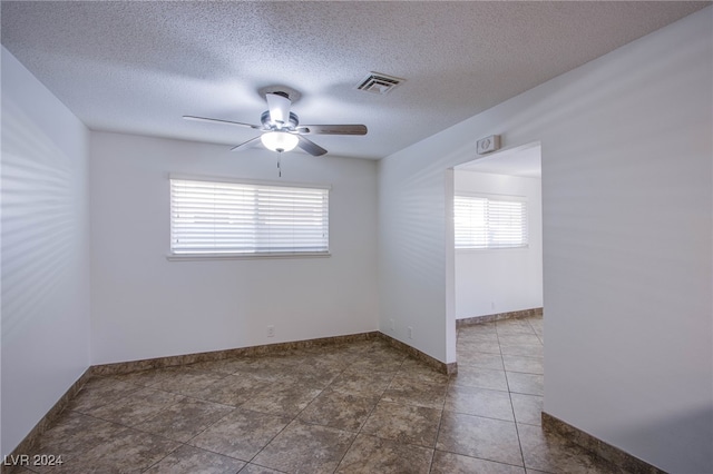 tiled spare room featuring ceiling fan and a textured ceiling