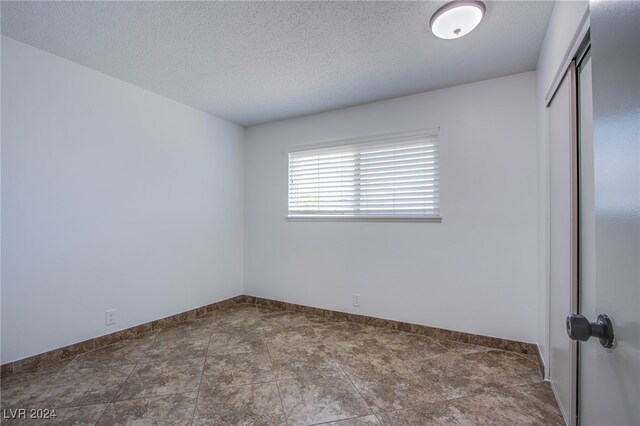 unfurnished room featuring a textured ceiling