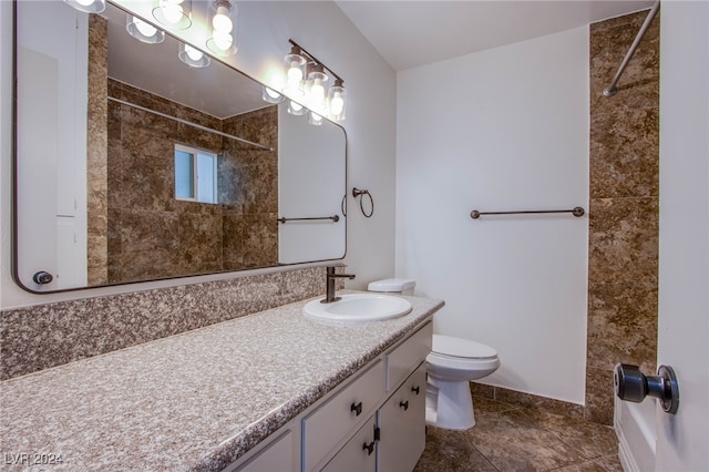 bathroom featuring tile patterned floors, vanity, toilet, and a tile shower