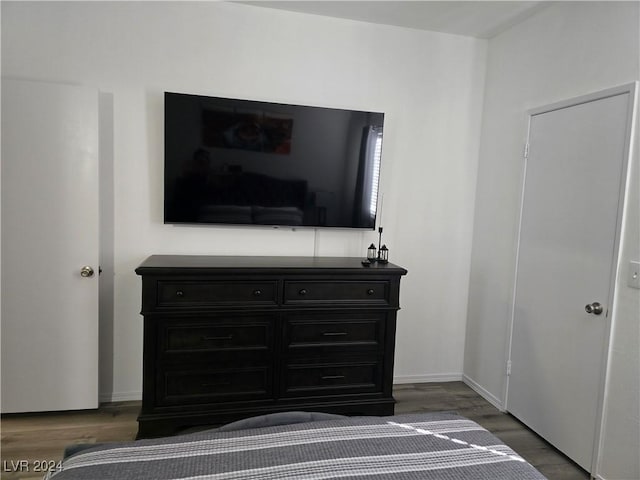 bedroom with dark hardwood / wood-style floors