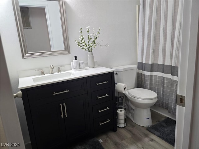 bathroom featuring vanity, wood-type flooring, and toilet