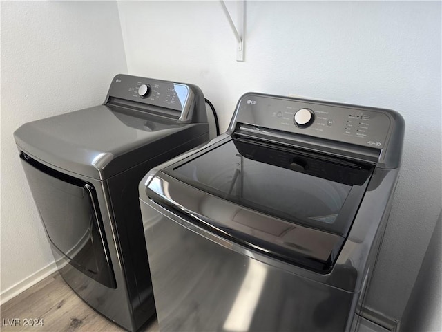 washroom with light hardwood / wood-style floors and washing machine and clothes dryer