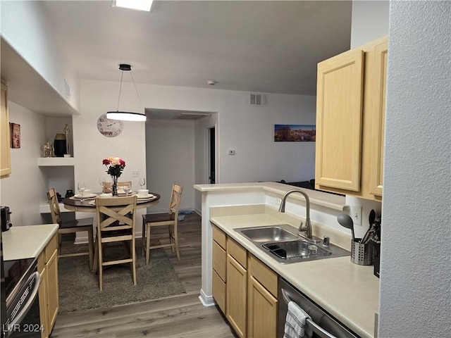 kitchen featuring hardwood / wood-style floors, light brown cabinetry, hanging light fixtures, and sink