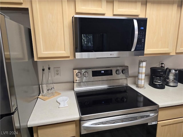 kitchen with light brown cabinetry and appliances with stainless steel finishes